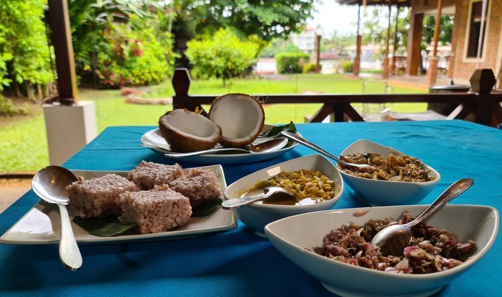 Sri Lankan Traditional Breakfast dishes on the table. The dishes include Coconut Milk Rice (aka Kiribath), Dhal/Lentil Curry, Seeni Sambol (Cooked onions) and Chile Pepper Paste.